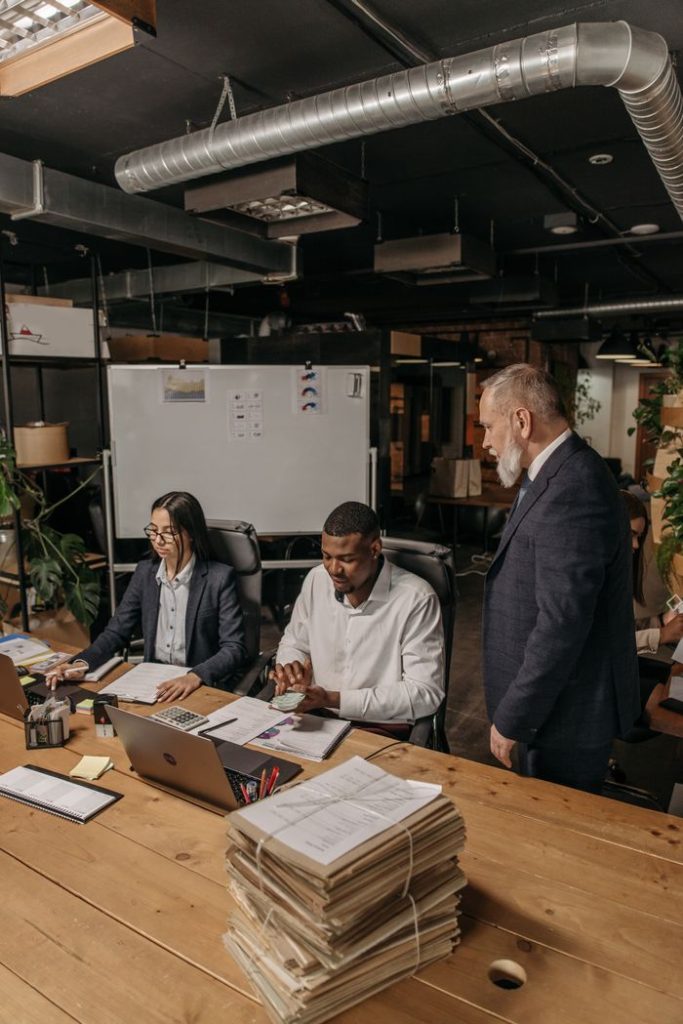 A diverse team collaborating in a modern office setting, reviewing documents and reports.